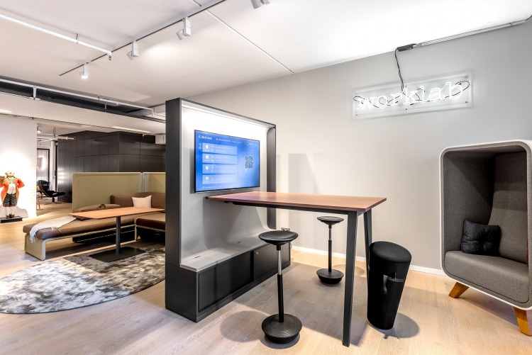 Stehtischtisch mit Monitor und Hockern für kurze Besprechungen.