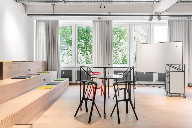 Flexibler Besprechungsraum mit Sitztreppe, Whiteboard auf Rollen und Stehtisch auf Rollen