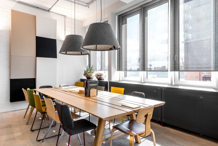 Großer Esstisch aus Eiche im WorkCafé mit verschiedenen Stühlen und zwei Lampen