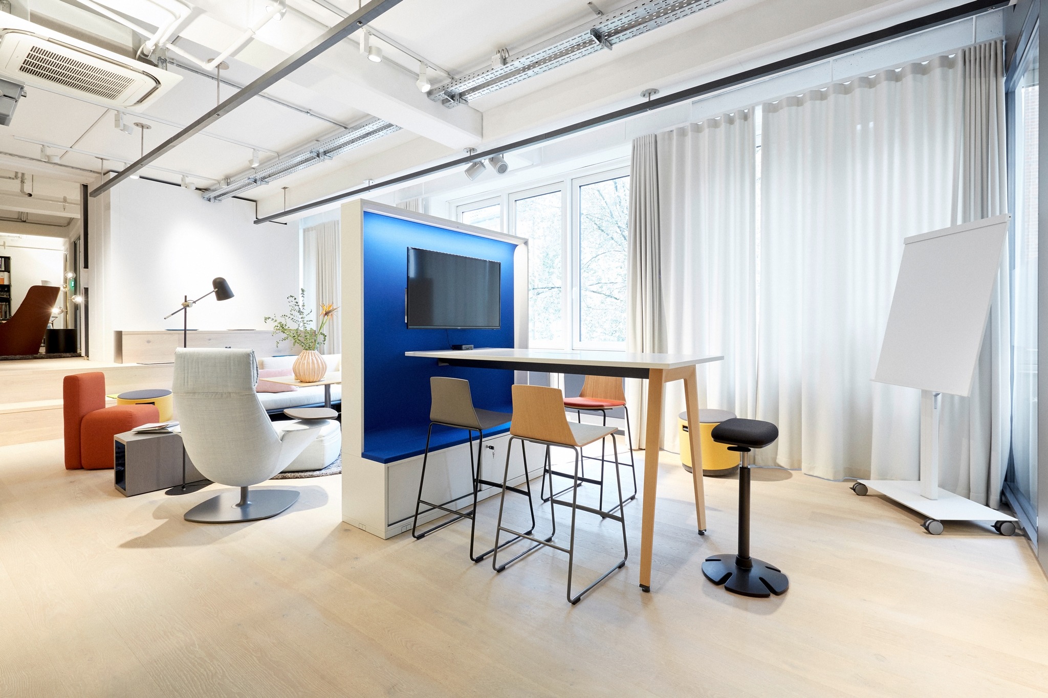 Stehtischtisch mit Monitor und Hockern für kurze Besprechungen.