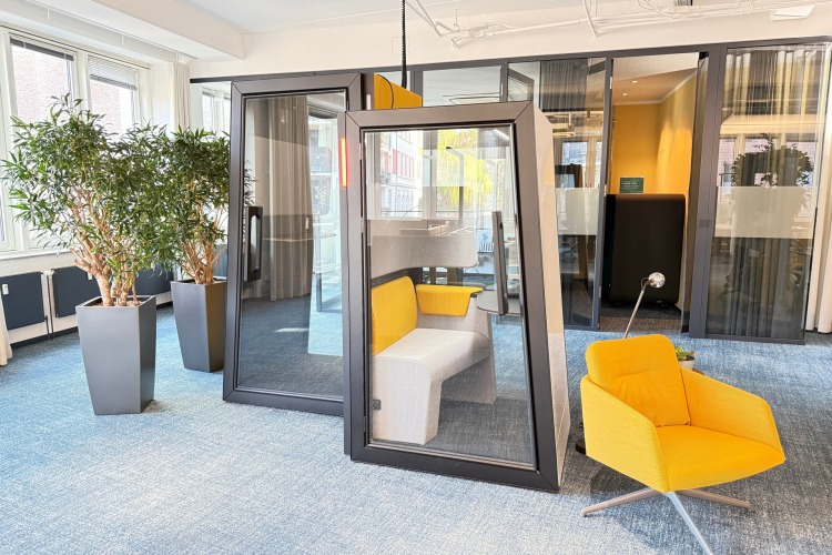 Zwei Telefonboxen in einem Großraumbüro.