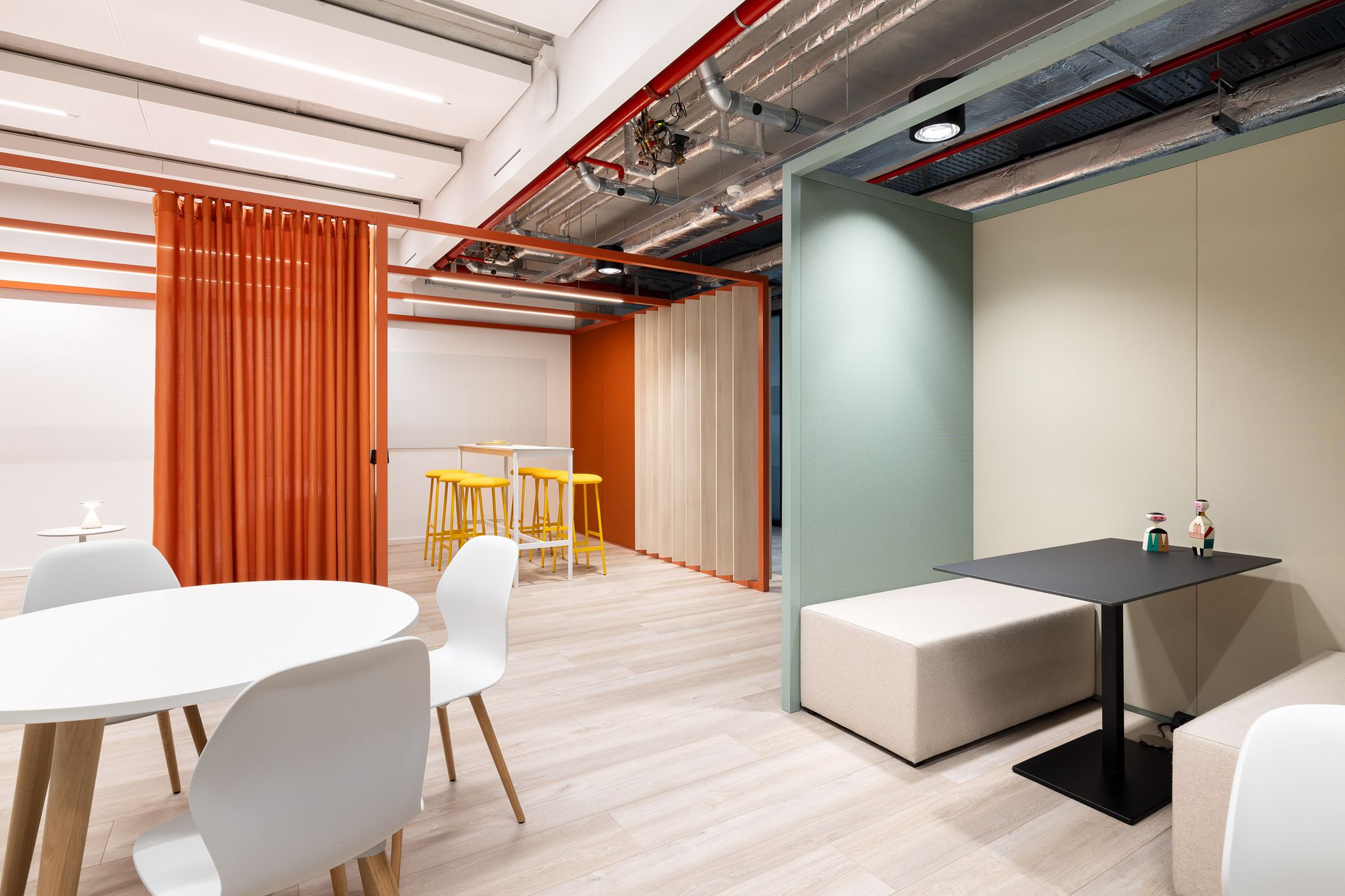 Verschiedene Sitzmöglichkeiten in einem Workcafe. Eine Sitznische und ein Stehtisch