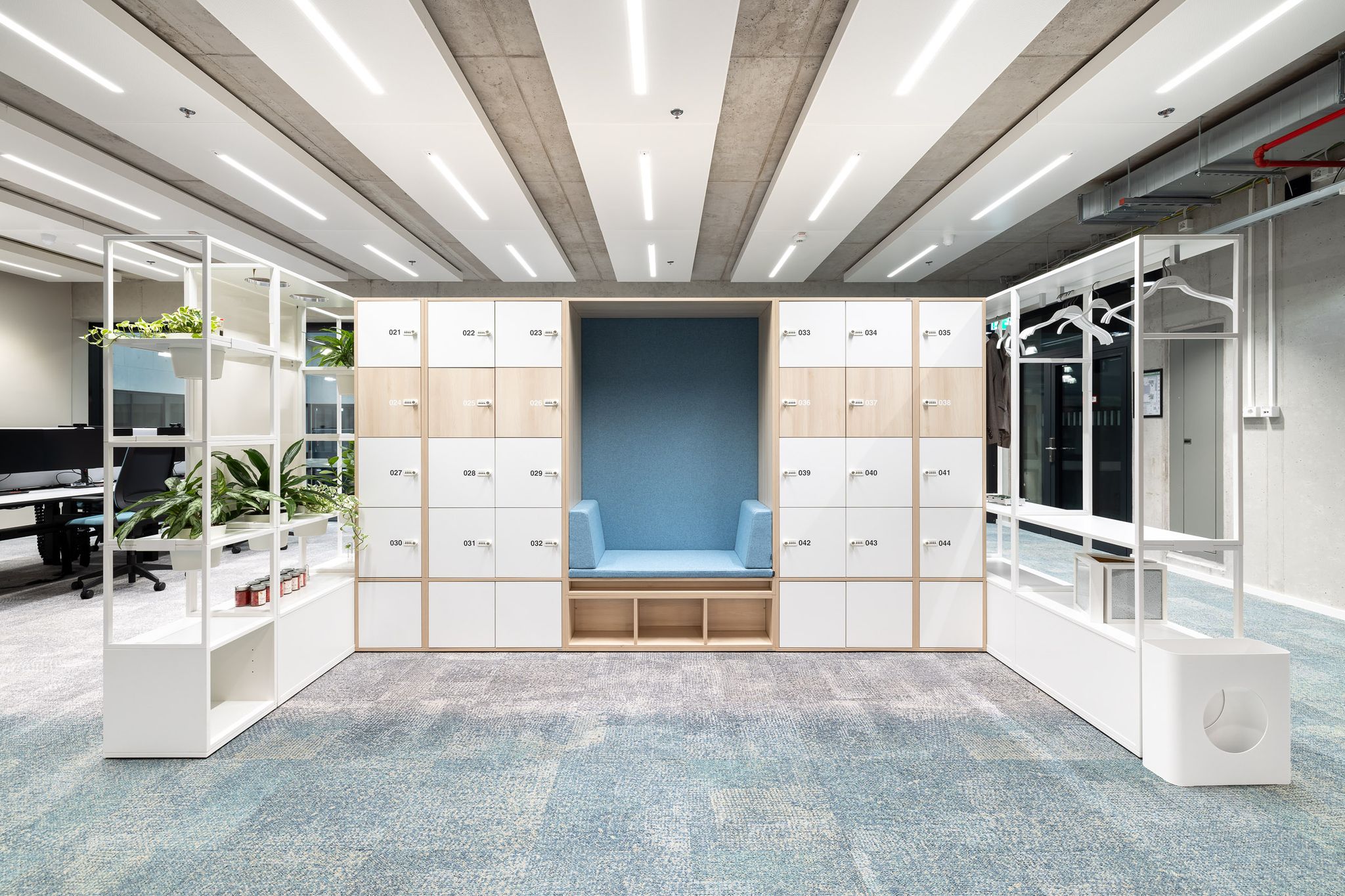 Ein Regalsystem mit integrierten Lockern, einer Sitznische und Garderobe. Holz und weiß.