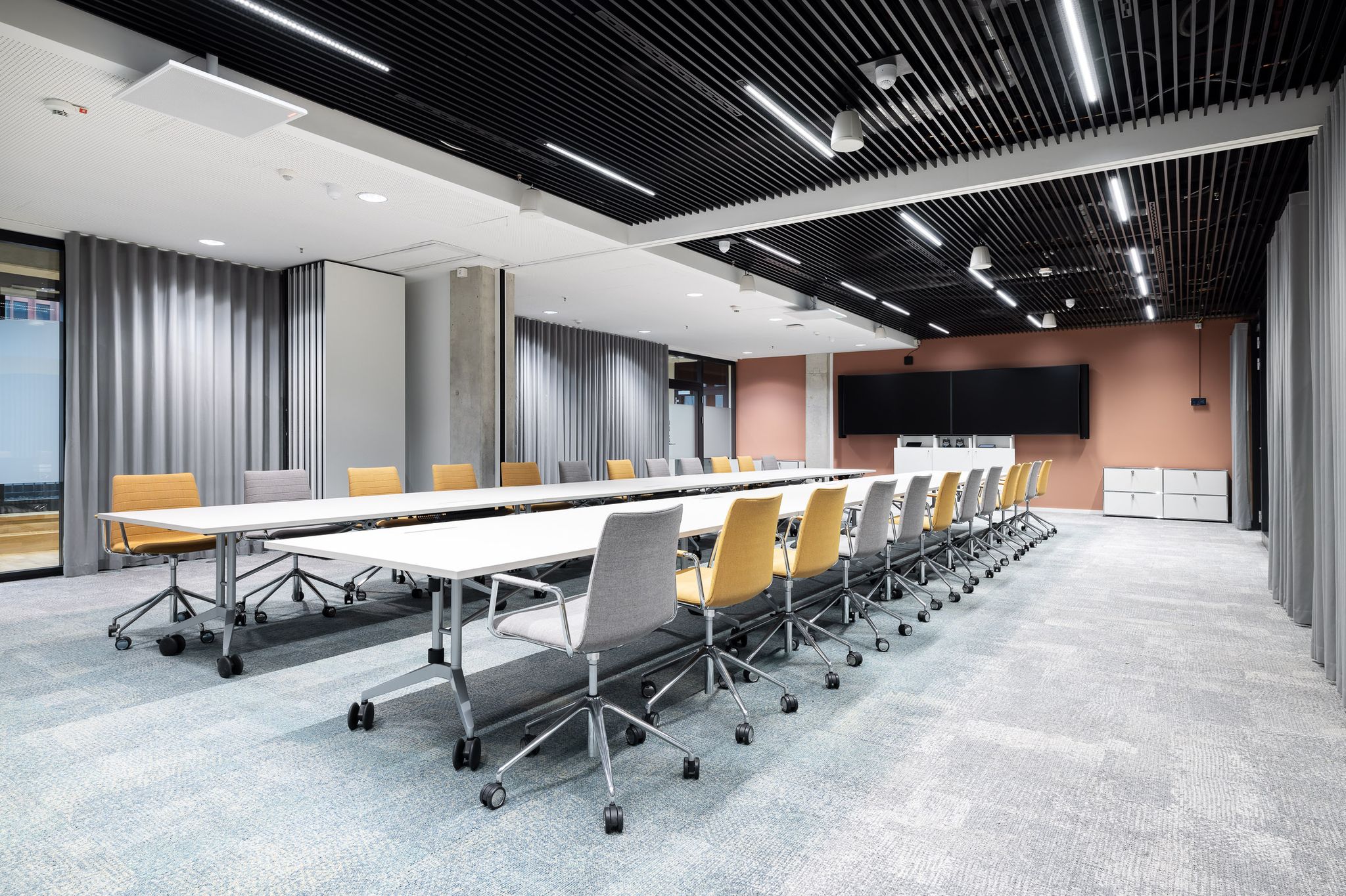 Großer Meetingraum mit langen Tischen und 20 Drehstühlen